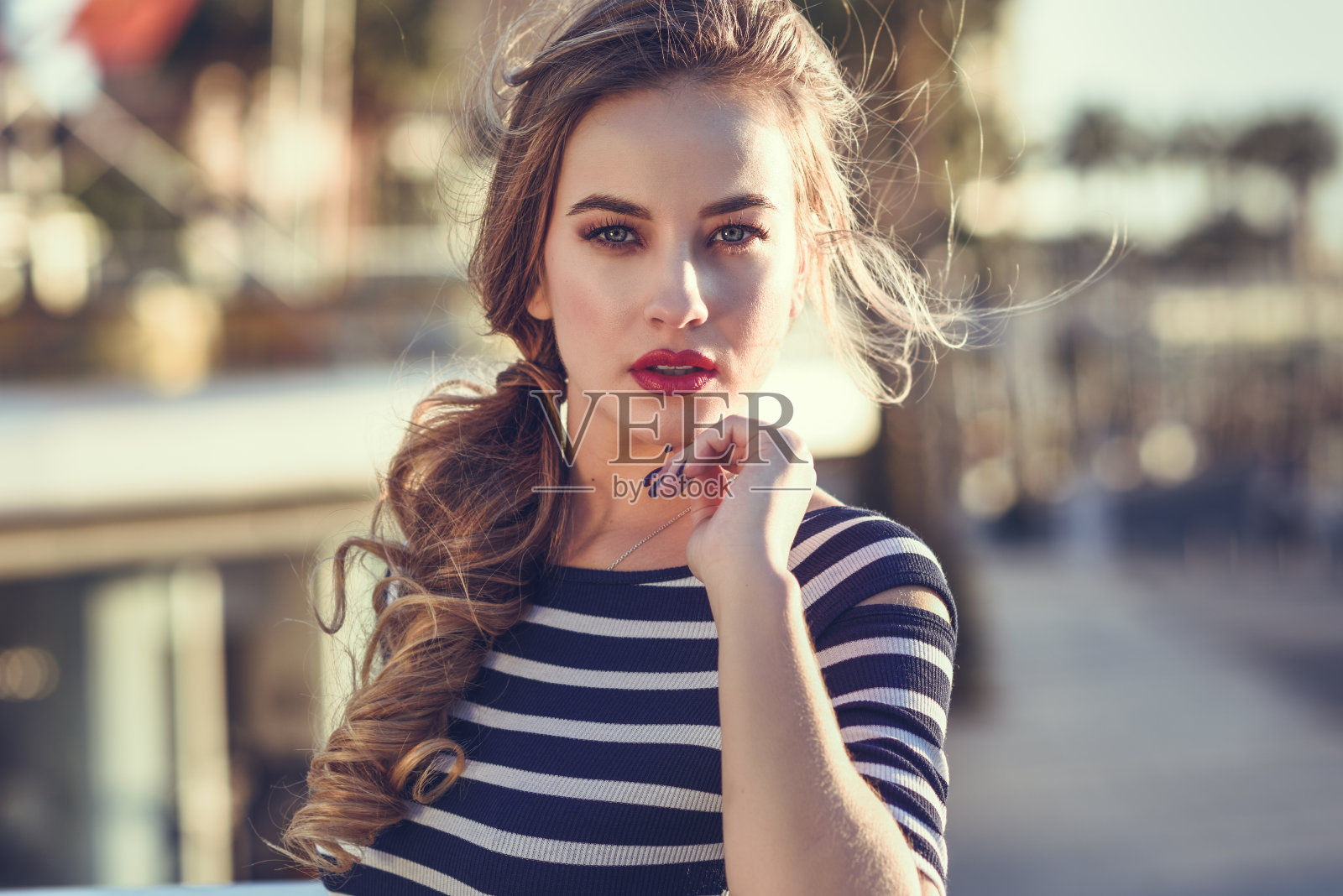 金发女郎，时尚模特，坐在城市背景中。照片摄影图片