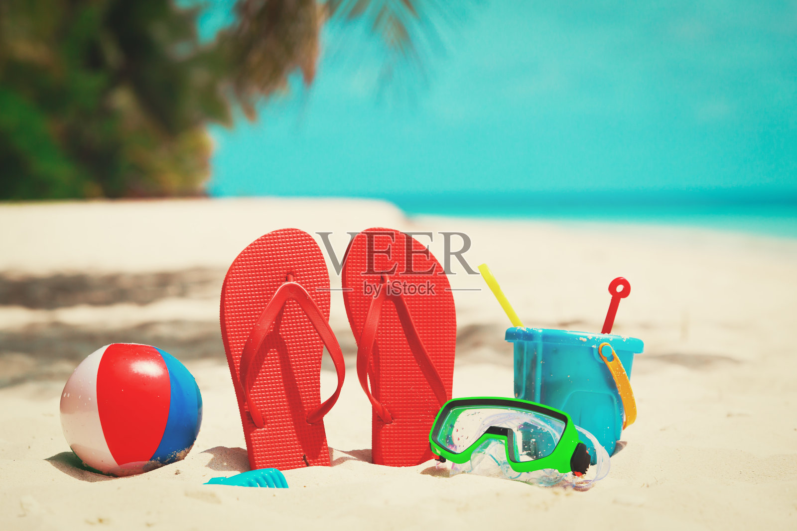 海滩上的彩色拖鞋、玩具和潜水面罩照片摄影图片
