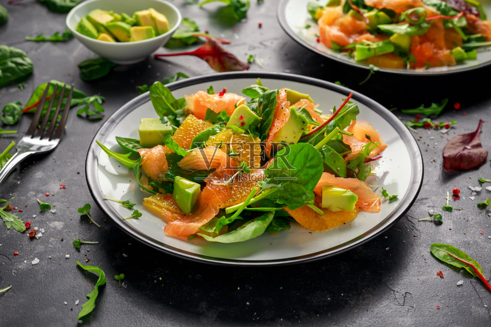 新鲜的三文鱼沙拉配鳄梨，橙和绿色蔬菜照片摄影图片