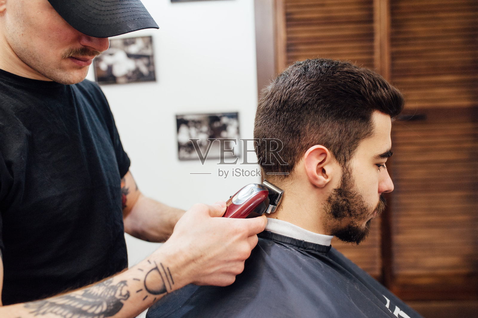 在理发店里剪时髦发型的男人。照片摄影图片