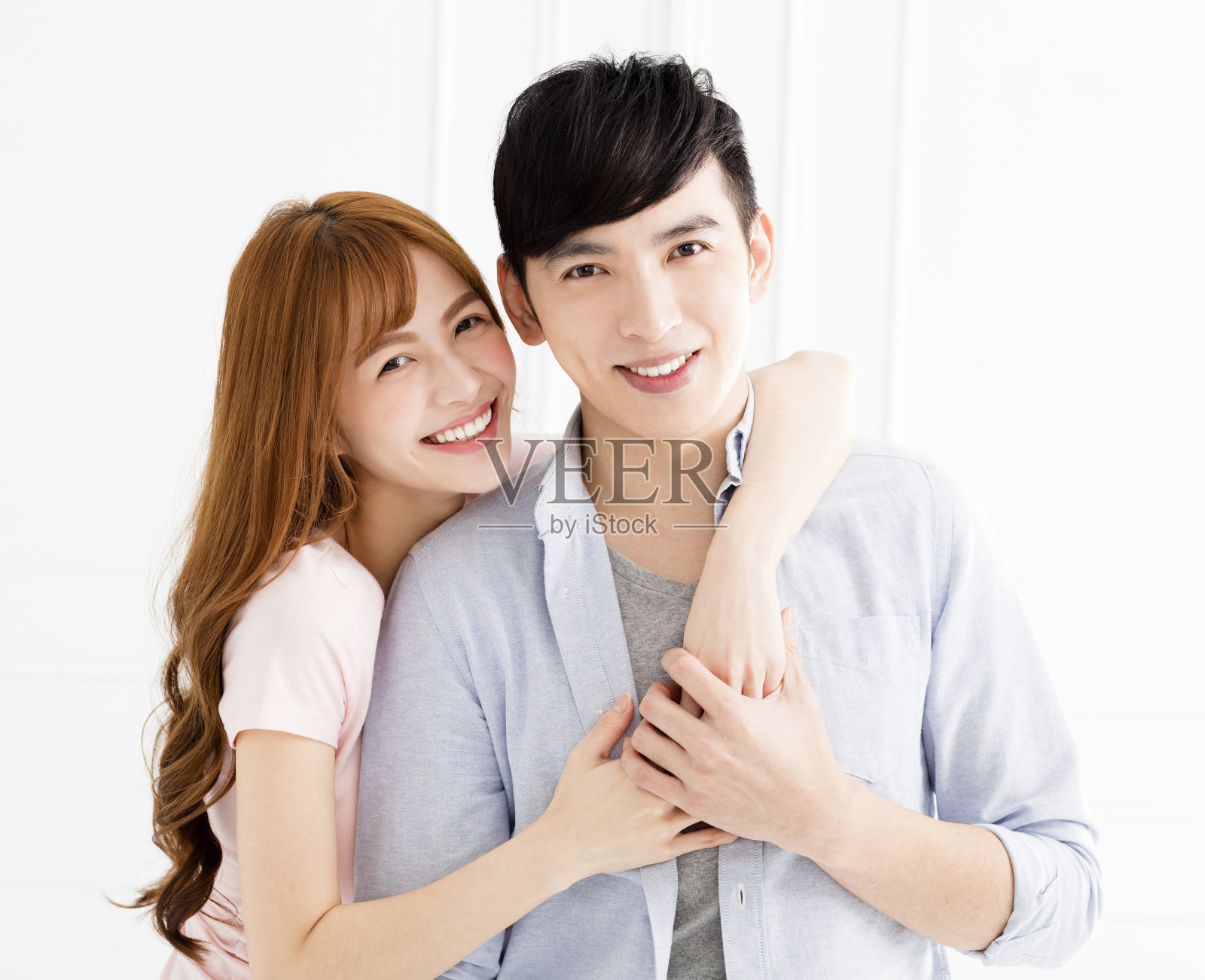 幸福的年轻亚洲夫妇在客厅拥抱照片摄影图片