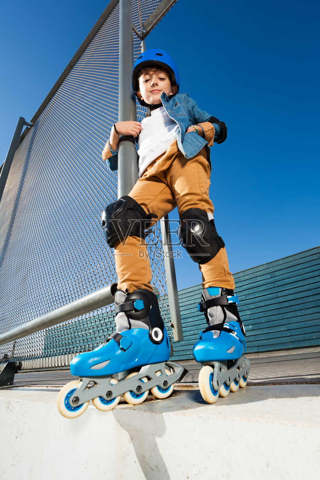 年轻的直排轮滑戴着头盔在滑板公园摆姿势照片摄影图片