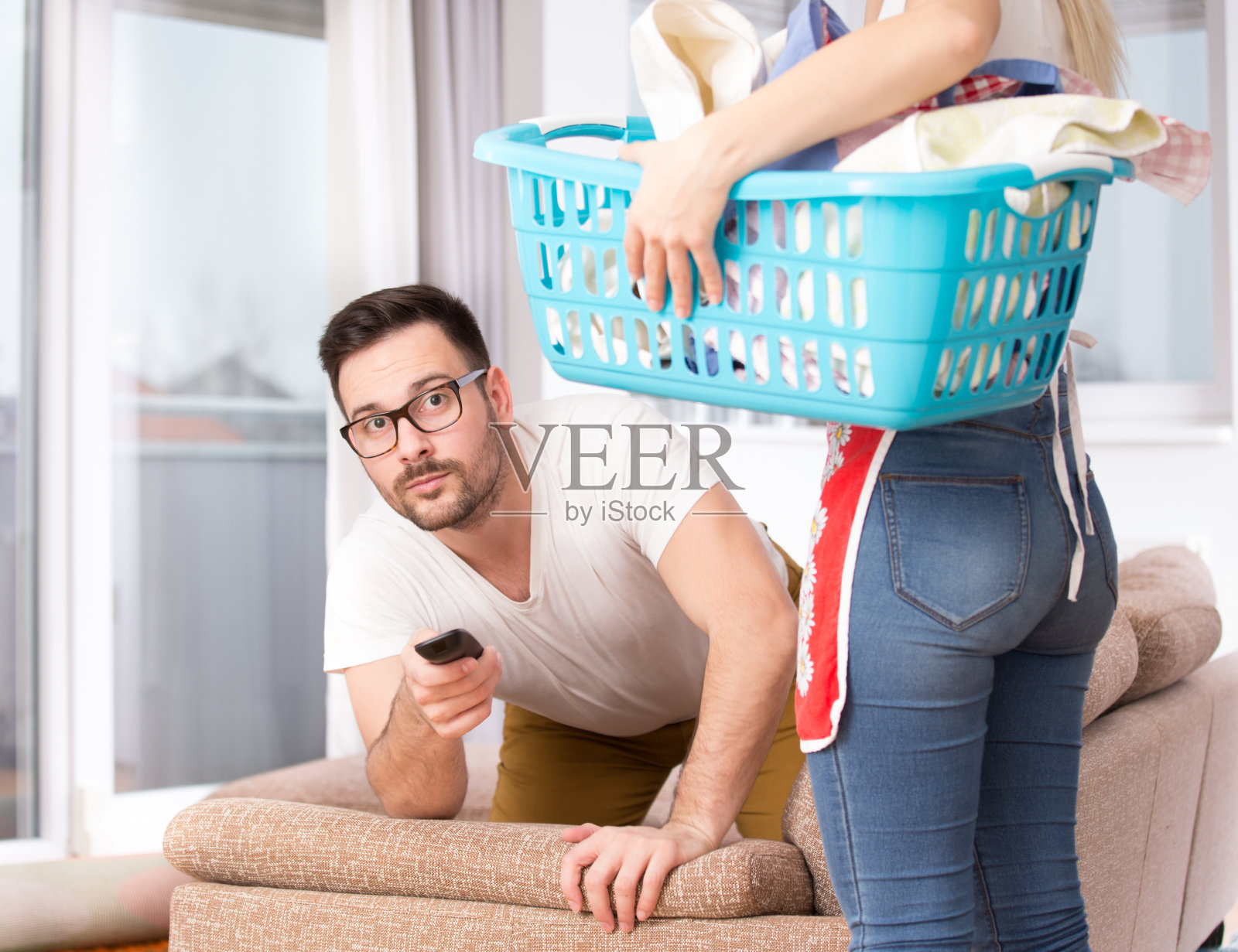 女人在做家务，男人在看电视照片摄影图片