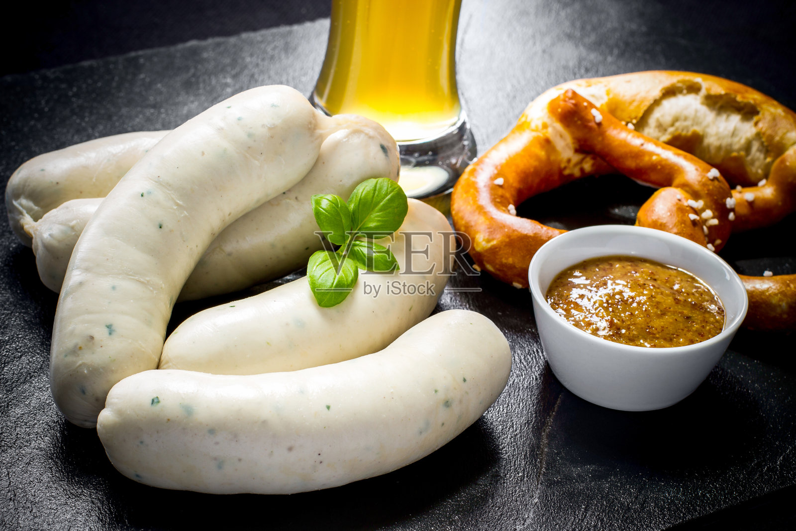 原汁原味的慕尼黑香肠配Hefeweizen和椒盐卷饼照片摄影图片