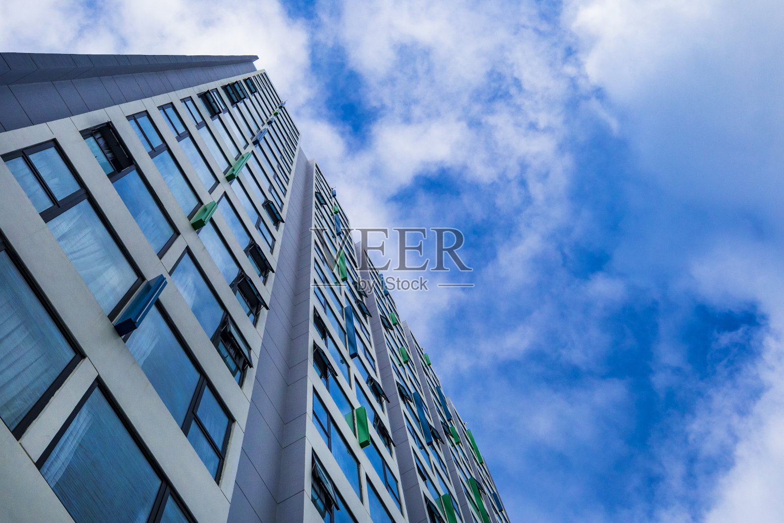 在蓝色多云的天空背景下的现代摩天大楼照片摄影图片
