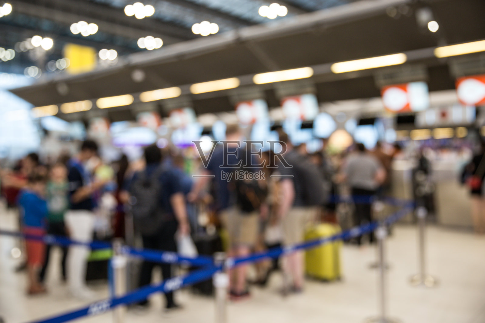 模糊的机场值机柜台上挤满了乘客。照片摄影图片