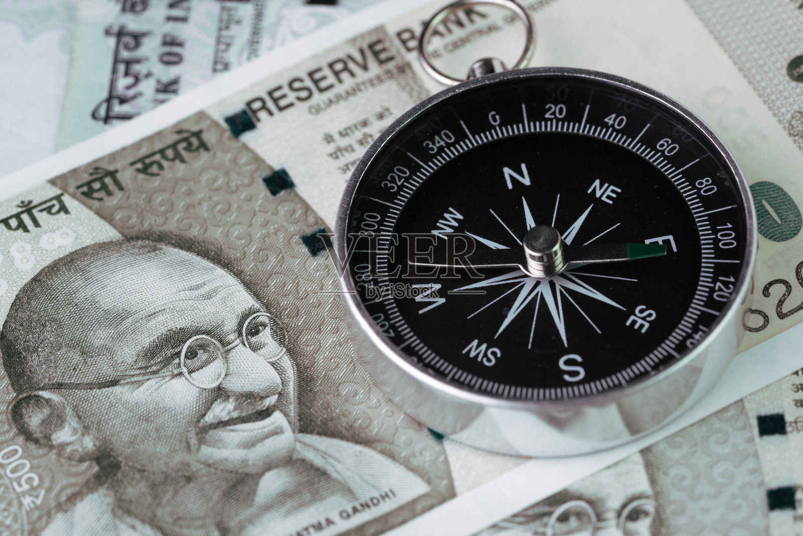 印度金融经济的方向，新兴市场高增长国家的概念，印度卢比钞票上的封闭指南针照片摄影图片