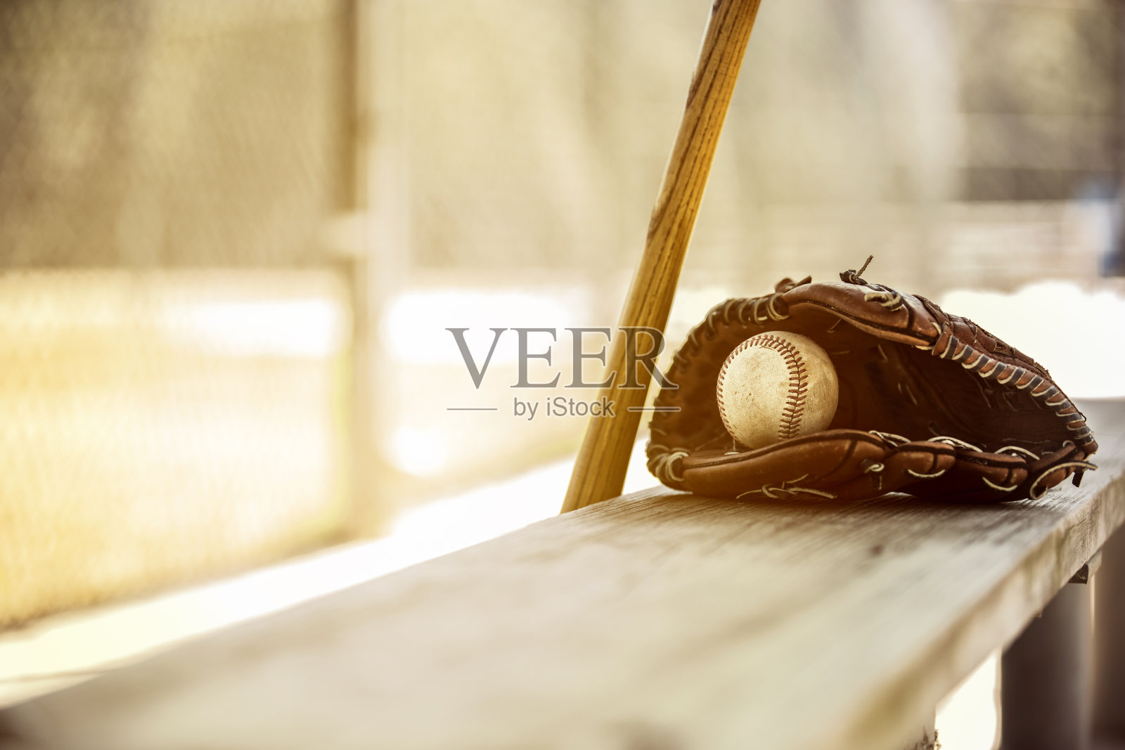 棒球赛季到了。教练席上的球棒、手套和球。照片摄影图片