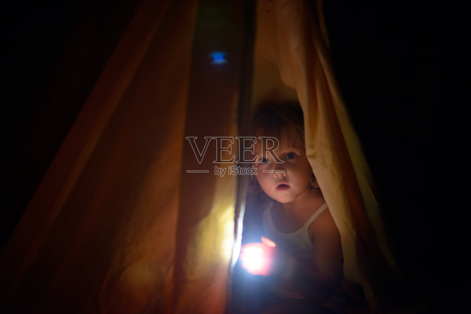 夜色中，盖着罩子的女孩手里拿着一盏小灯照片摄影图片
