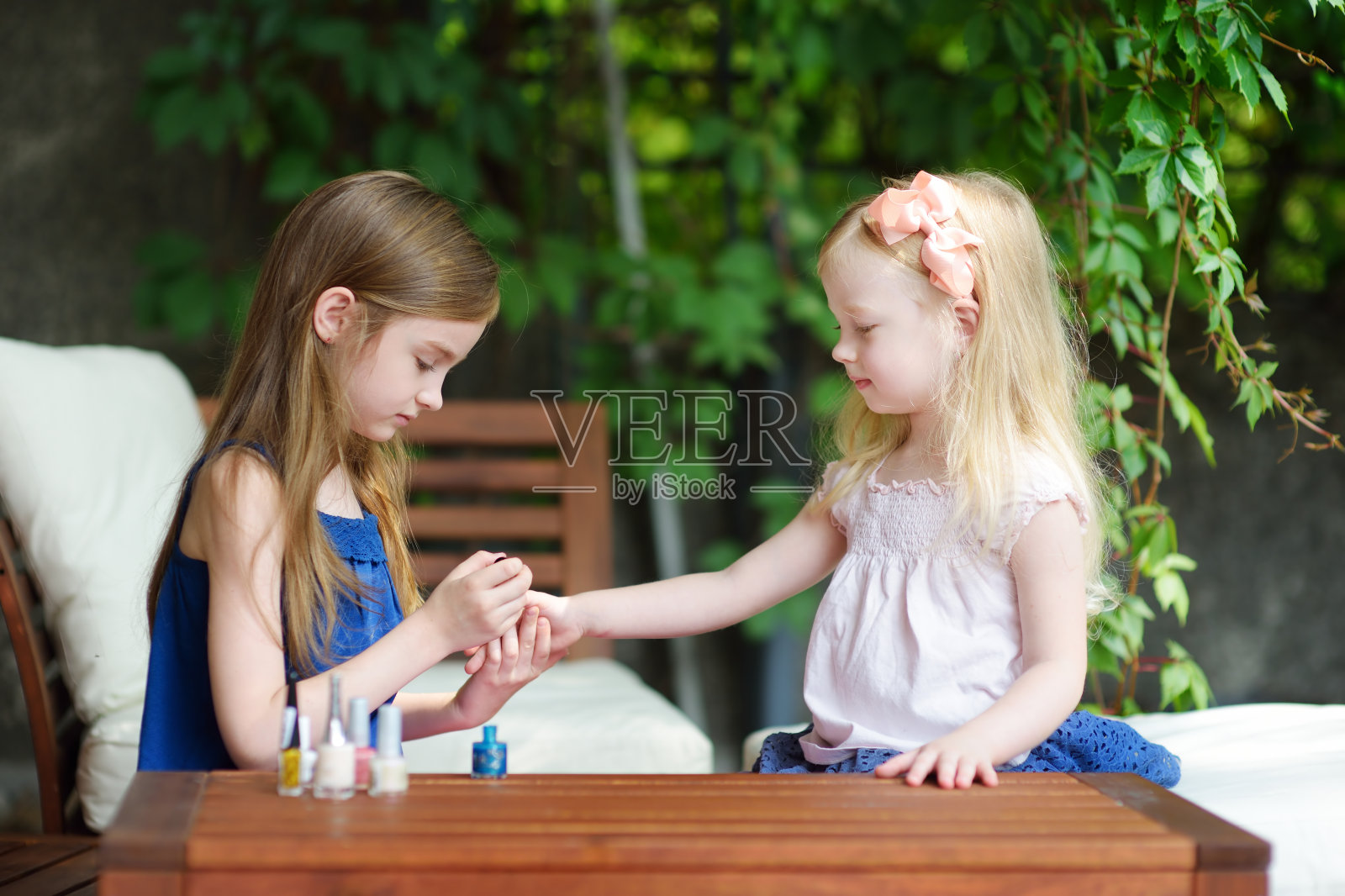 可爱的小女孩在家里玩彩色指甲油做指甲和涂指甲照片摄影图片