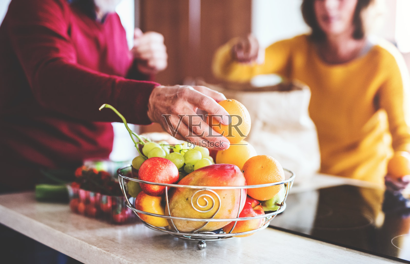 一对老年夫妇在厨房里拆水果。照片摄影图片