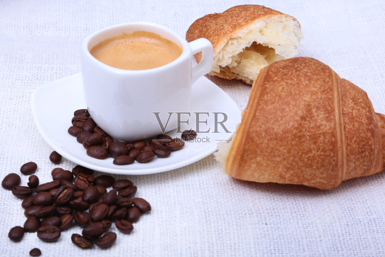 经典的浓缩咖啡在白色的杯子，羊角面包和咖啡豆在白色的背景。前视图。照片摄影图片