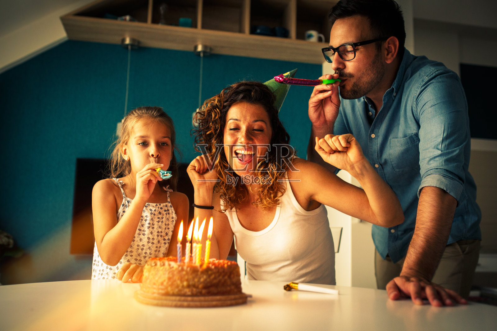 母亲的生日。丈夫和女儿用生日蛋糕给母亲和妻子惊喜。照片摄影图片