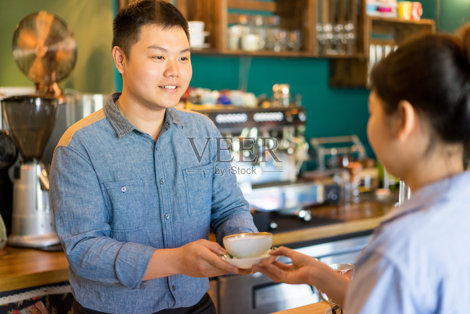 快乐的亚洲男人给顾客美味的咖啡照片摄影图片