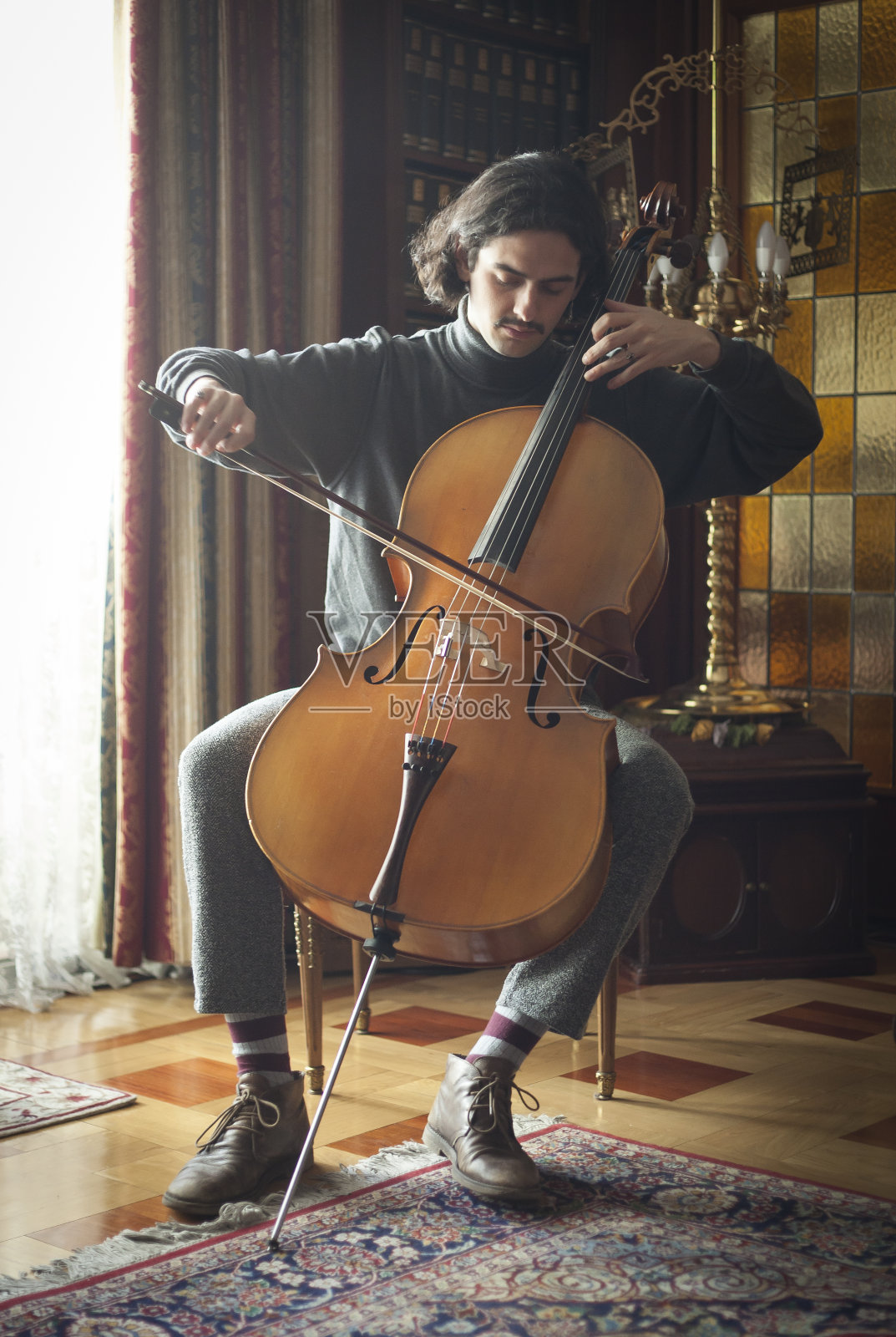 年轻的大提琴手在演奏大提琴照片摄影图片