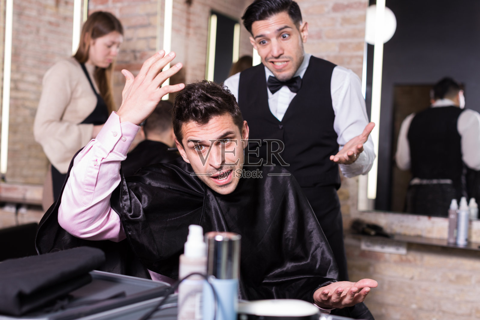 震惊的男人与道歉的男性发型师照片摄影图片