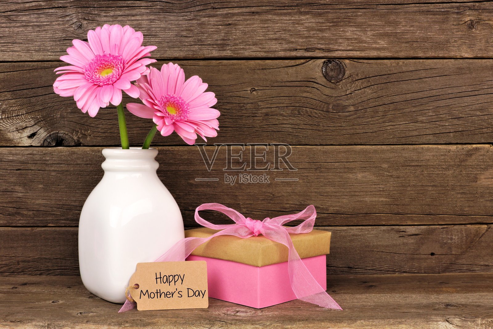 母亲节快乐的标签与礼物和粉红色的花在乡村木材照片摄影图片