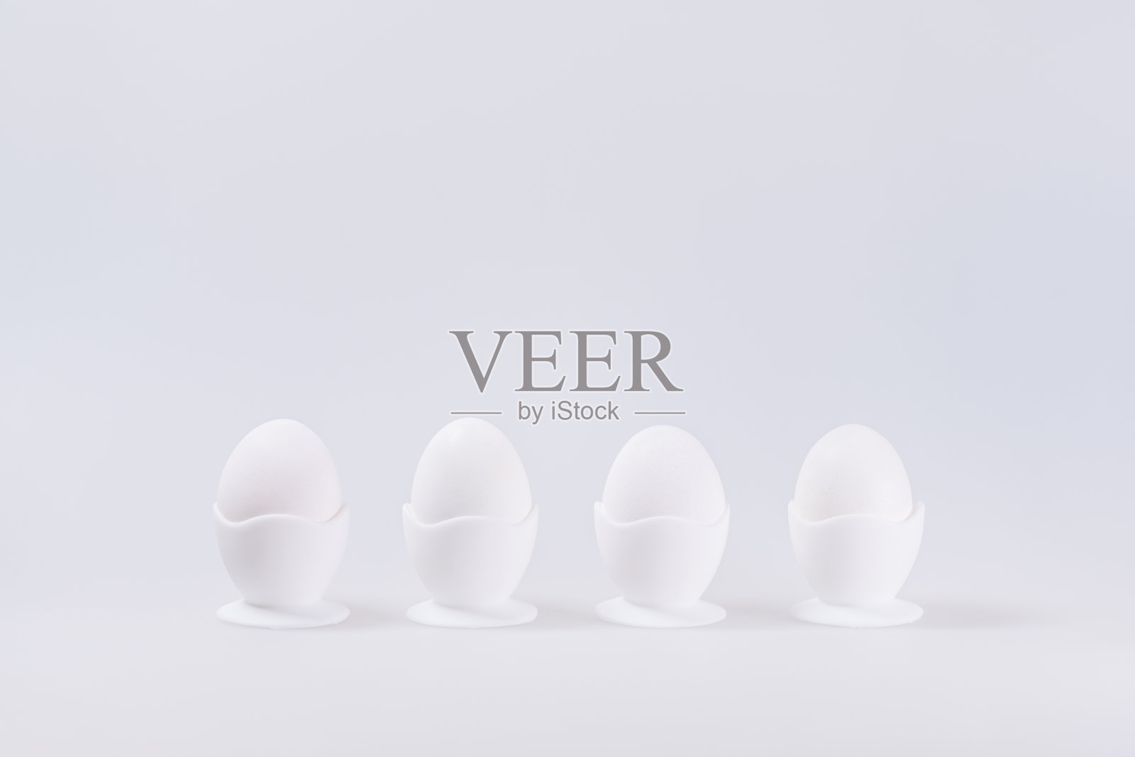 4个白色的鸡蛋在鸡蛋杯，孤立在白色背景与文字空间照片摄影图片