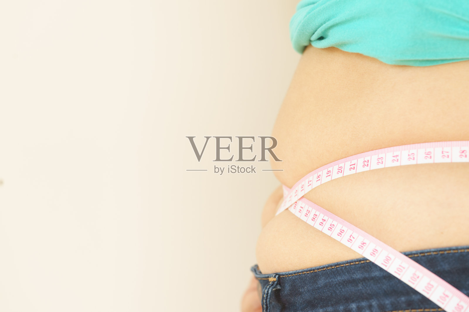 胖嘟嘟的女人试图测量自己的胖肚子照片摄影图片