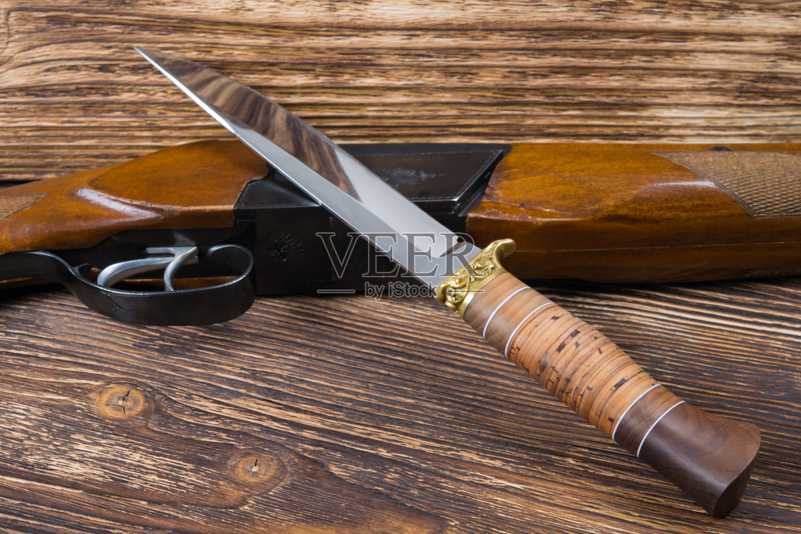 武器和猎刀放在木制背景上照片摄影图片