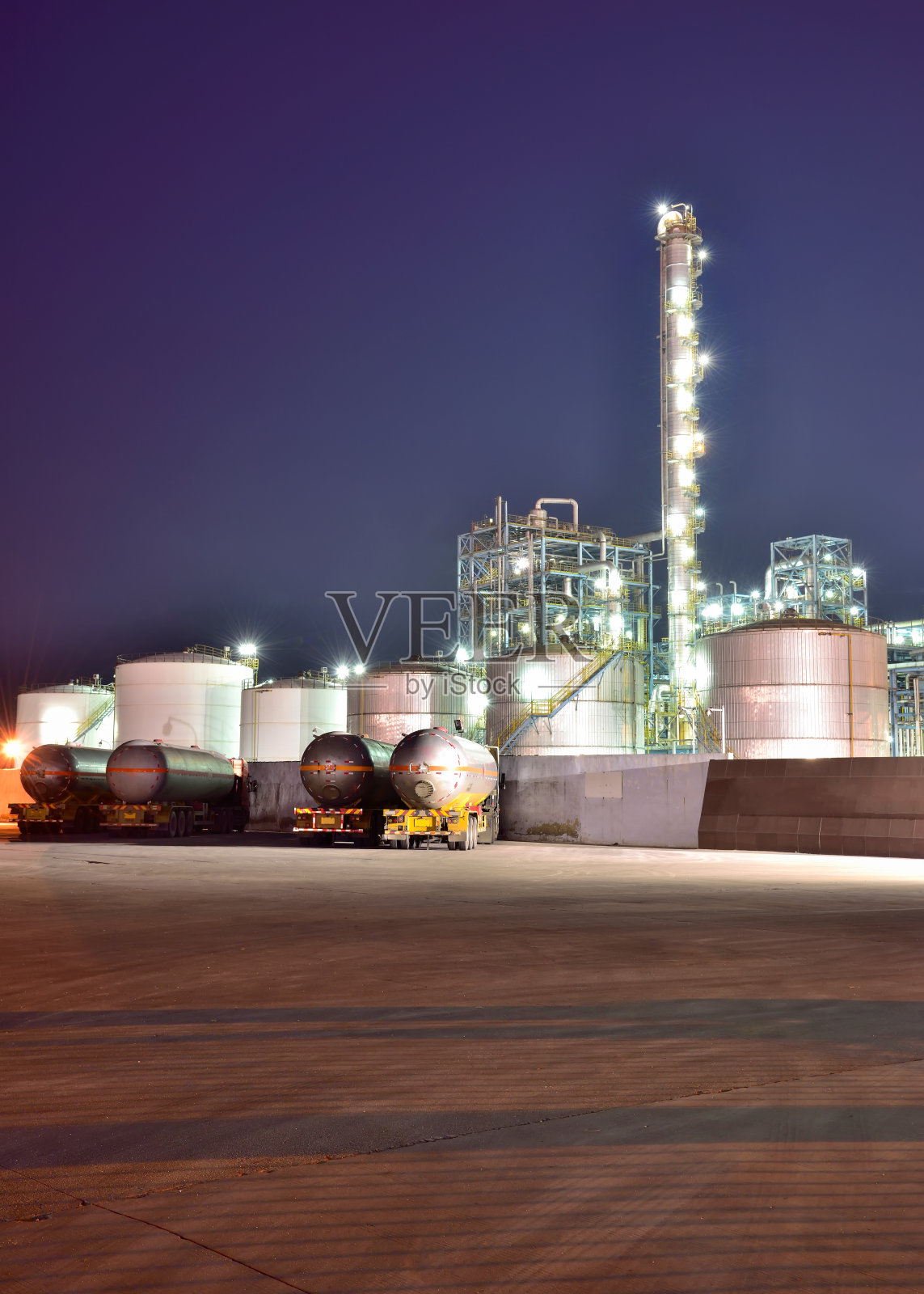 傍晚炼油厂的背景是油罐车照片摄影图片