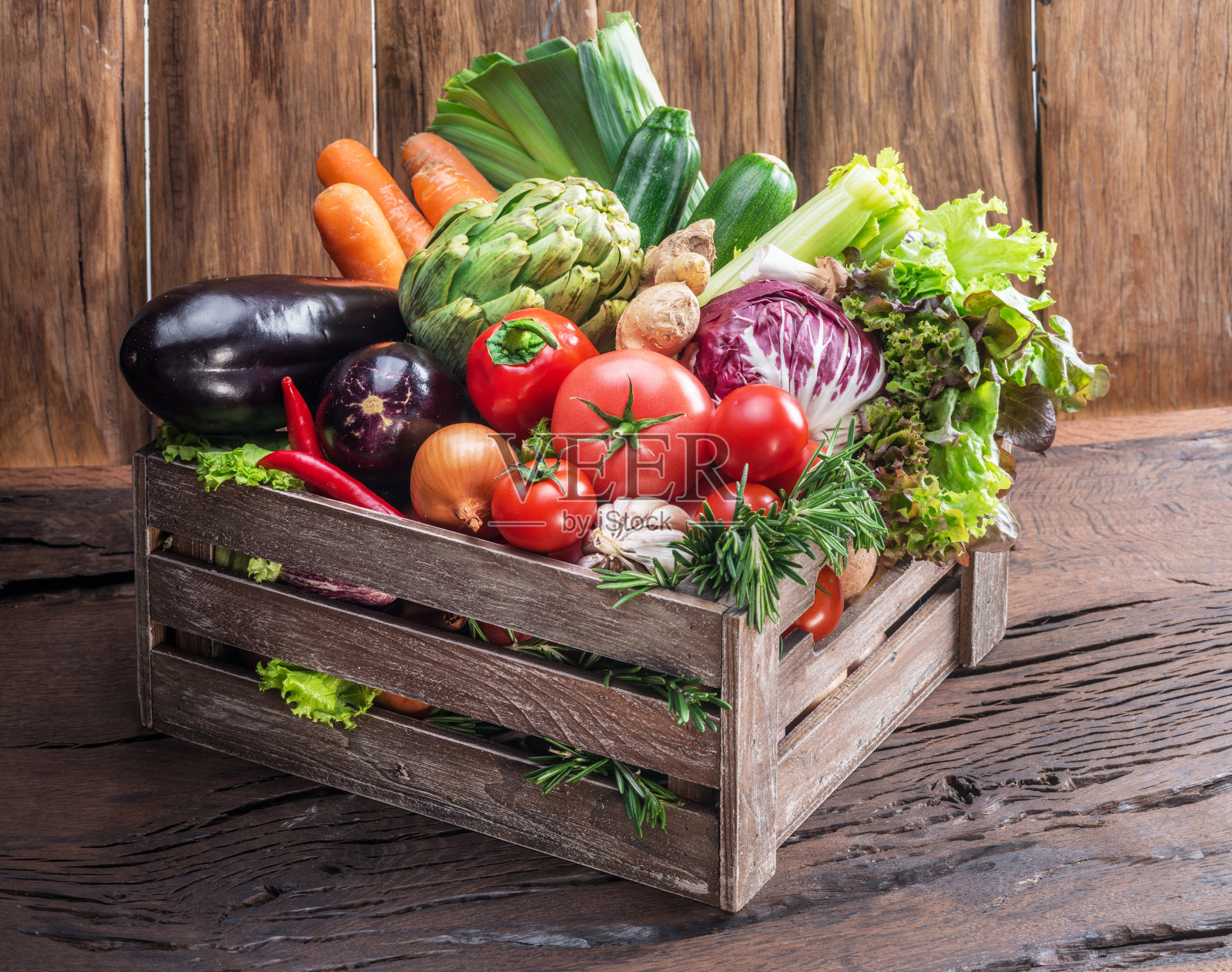 新鲜的彩色蔬菜装在木箱里。照片摄影图片