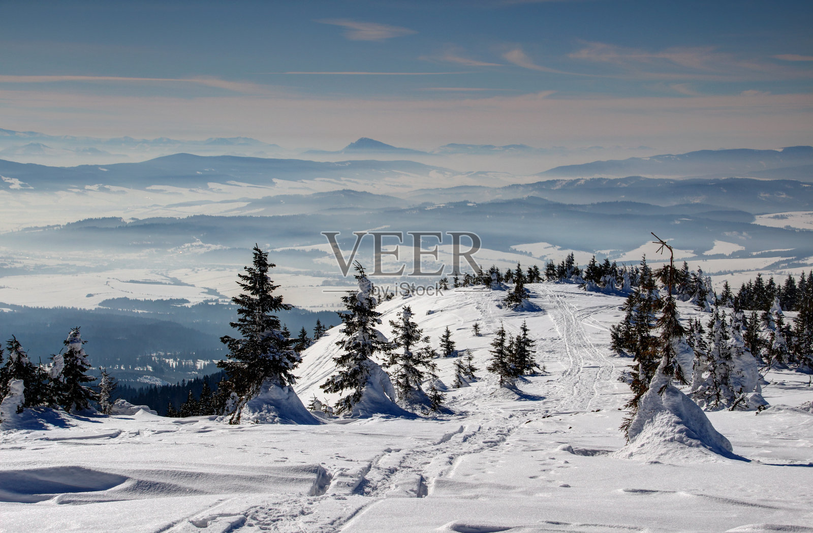 滑雪道，松树和朦胧的蓝色山脊照片摄影图片