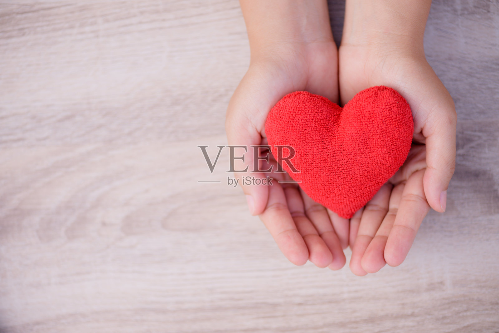 医疗、爱心、器官捐赠、家庭保险、CSR理念。成人和儿童手握手工制作的红心木制背景。照片摄影图片
