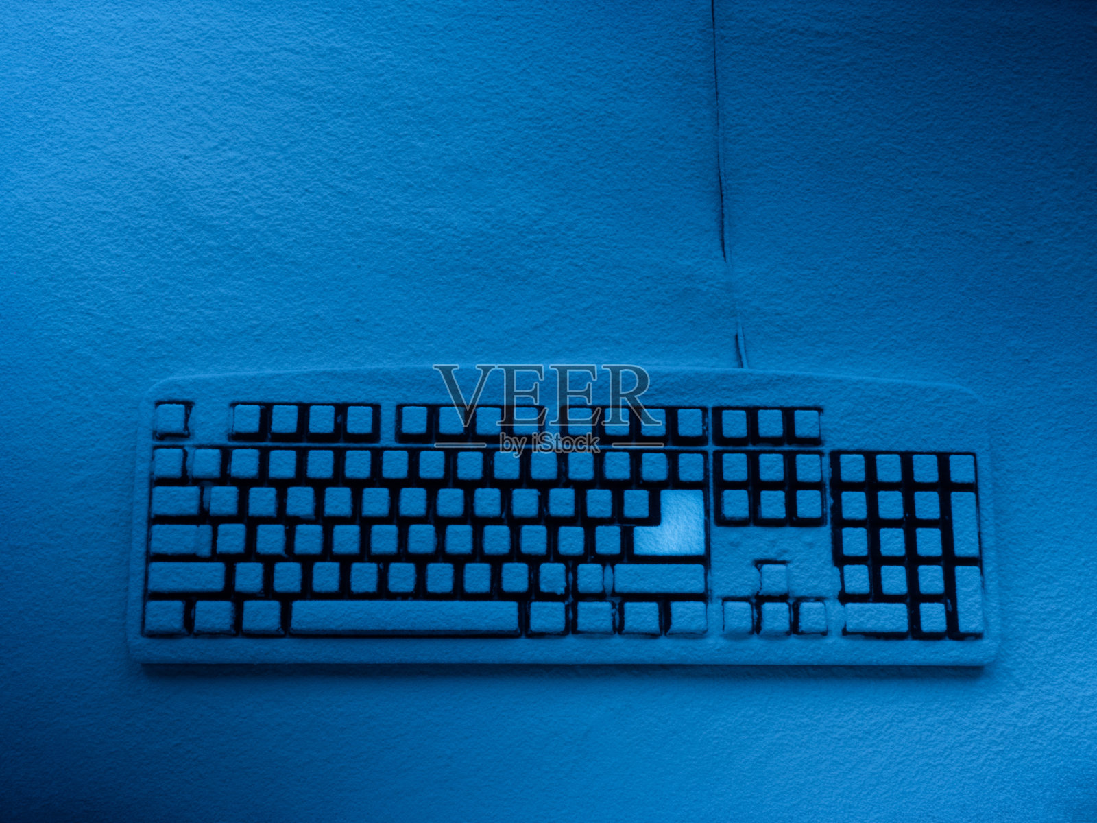 电脑键盘上覆盖着雪，用青色霓虹灯和明亮的进入按钮复制空间照明照片摄影图片