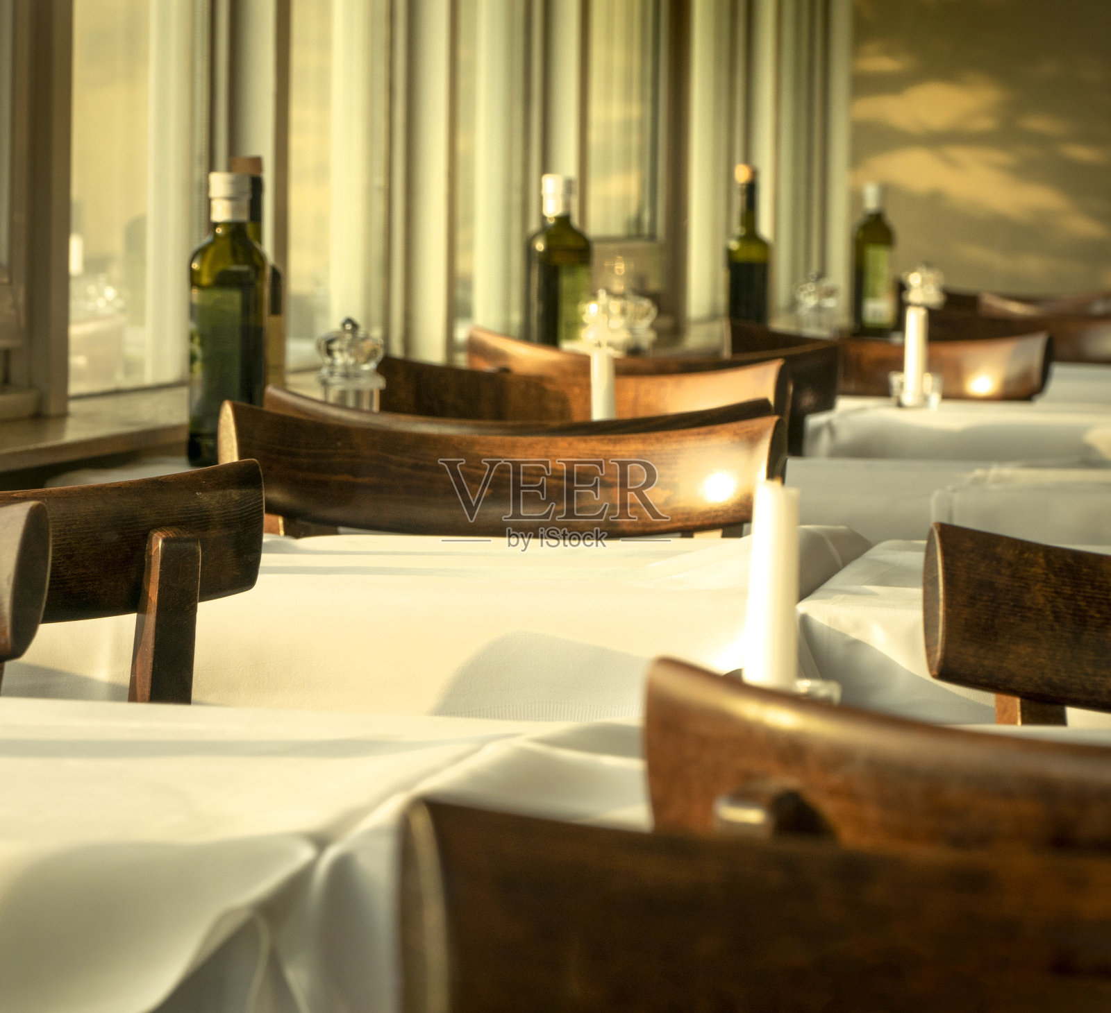 餐厅的桌子铺着白色的桌布和棕色的木椅照片摄影图片