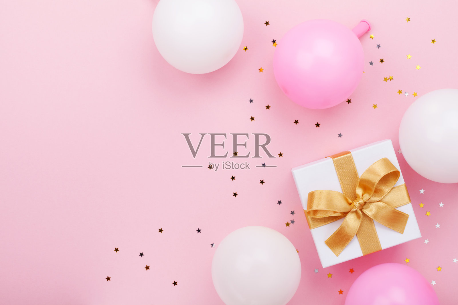 礼品或礼盒，气球和五彩纸屑在粉红色的桌子上顶视图。平躺用于生日、母亲节或婚礼。照片摄影图片