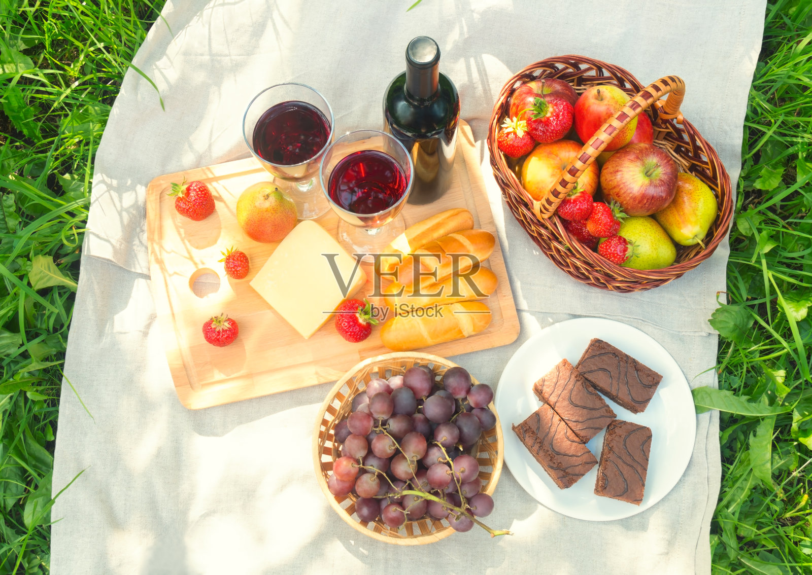 野餐套餐，配有红酒、奶酪、水果和蛋糕。照片摄影图片