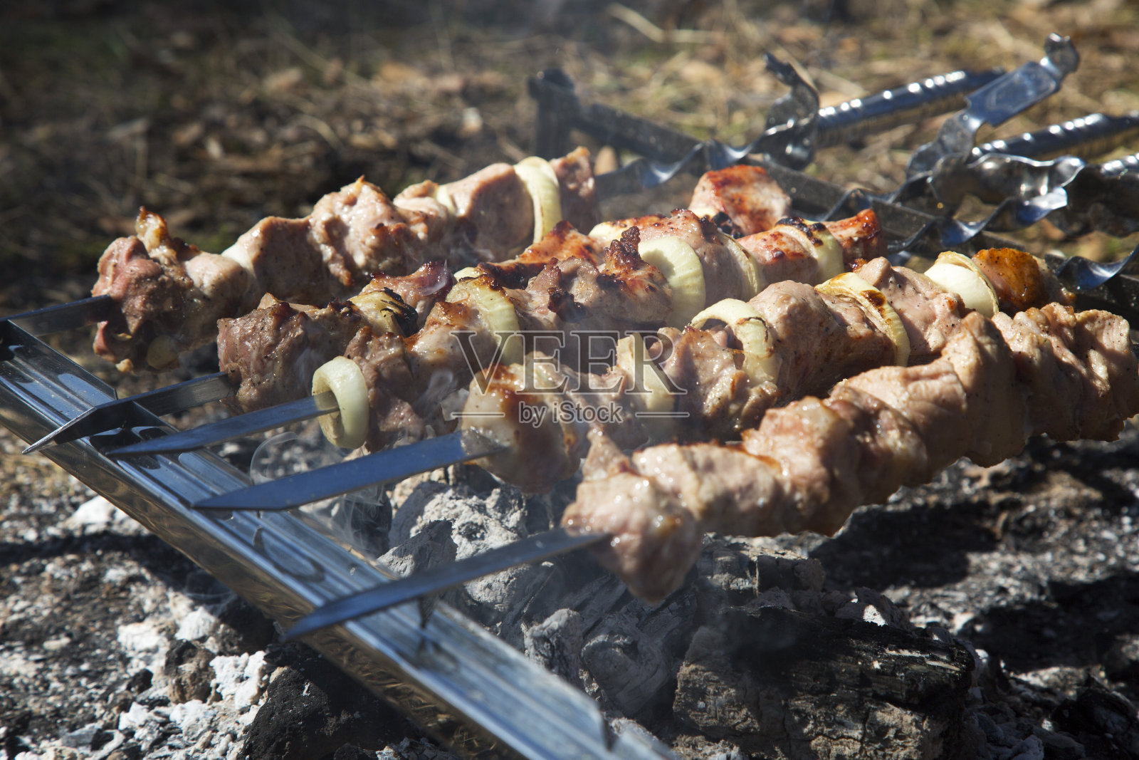 多汁和美味的猪肉串串在露天烧烤。户外烧烤派对的概念。初春的一天。肉的背景。特写视图。照片摄影图片