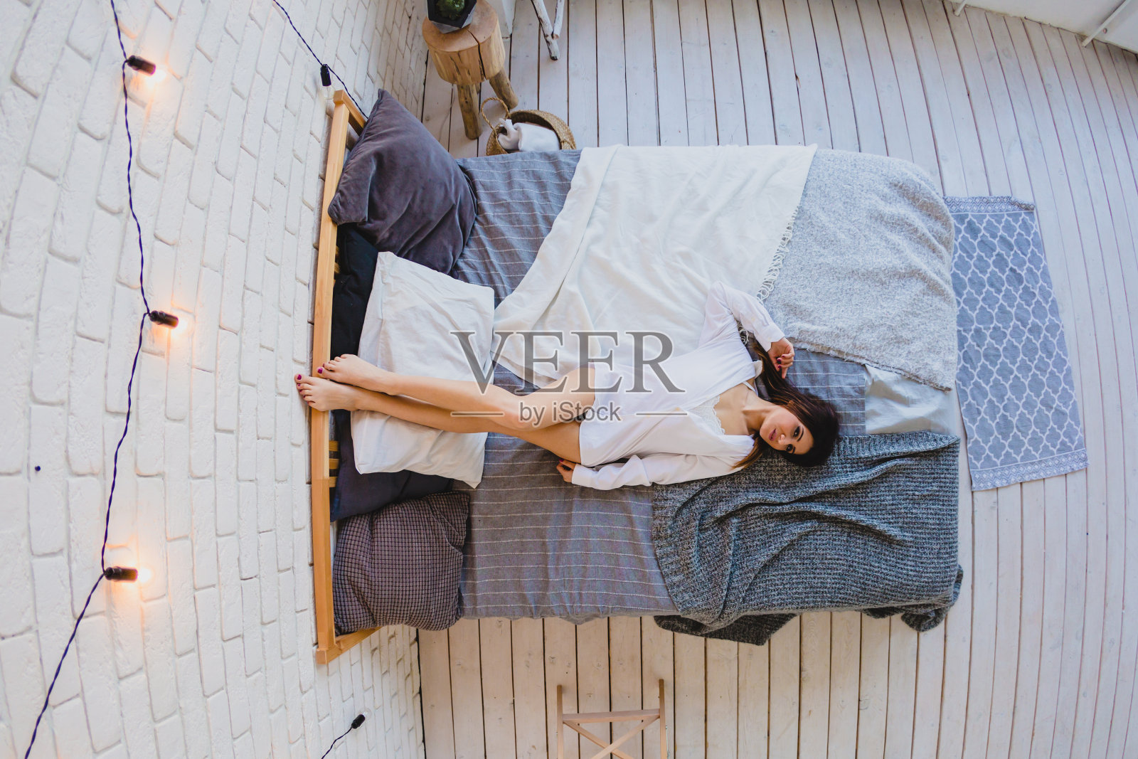性感苗条的黑发女子躺在一张大床上照片摄影图片
