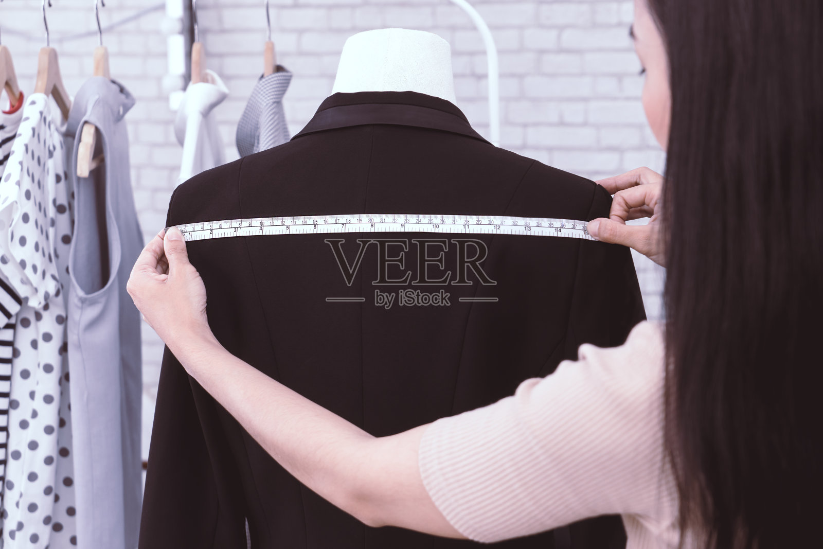 日本时装设计师正在测量夹克的肩部照片摄影图片