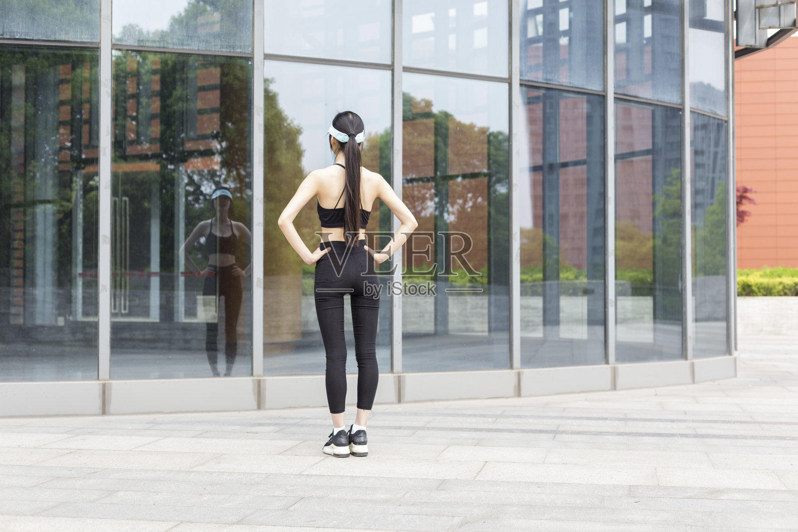 女人在玻璃建筑前做热身照片摄影图片