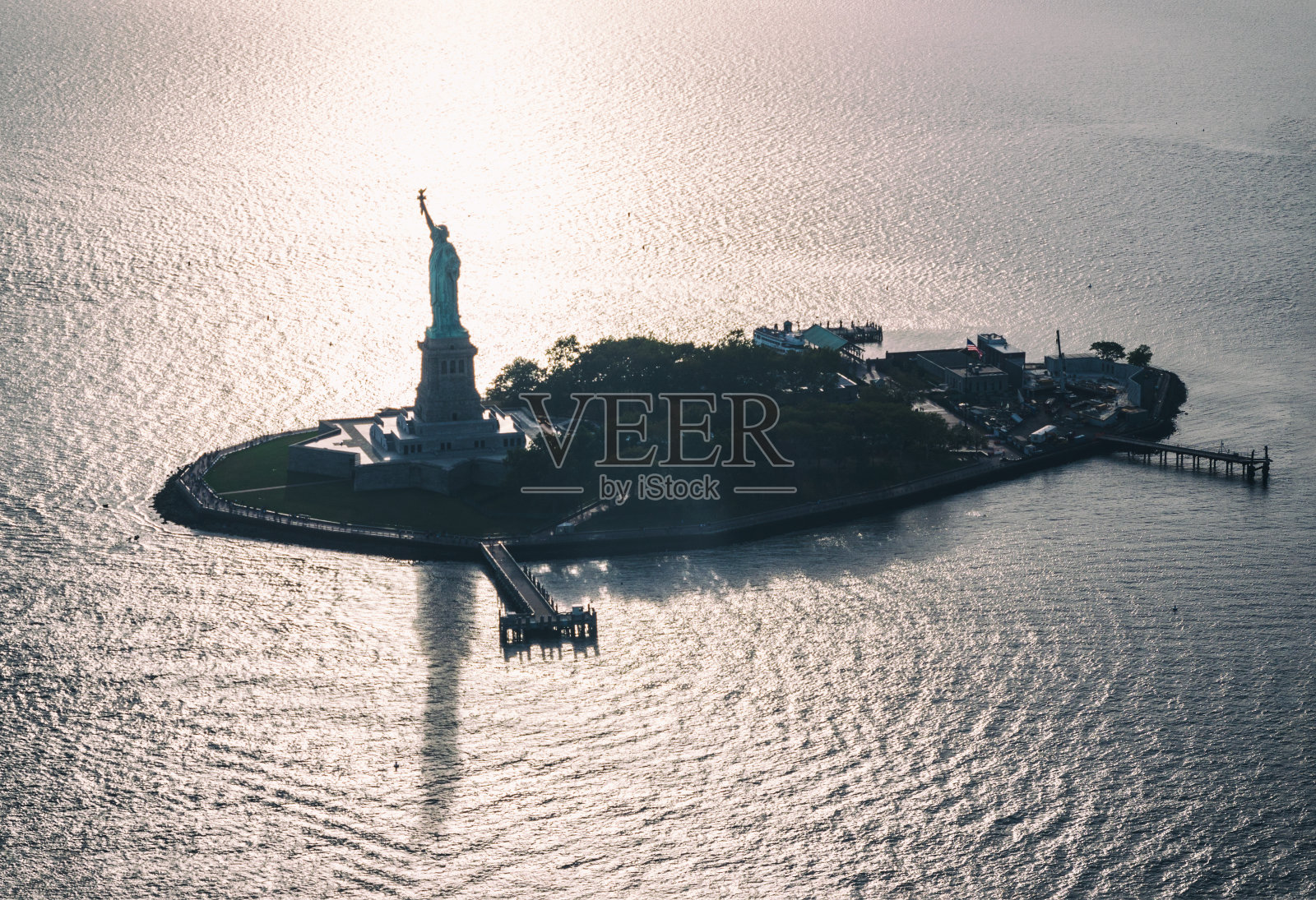 背光鸟瞰自由岛和自由女神像。纽约照片摄影图片