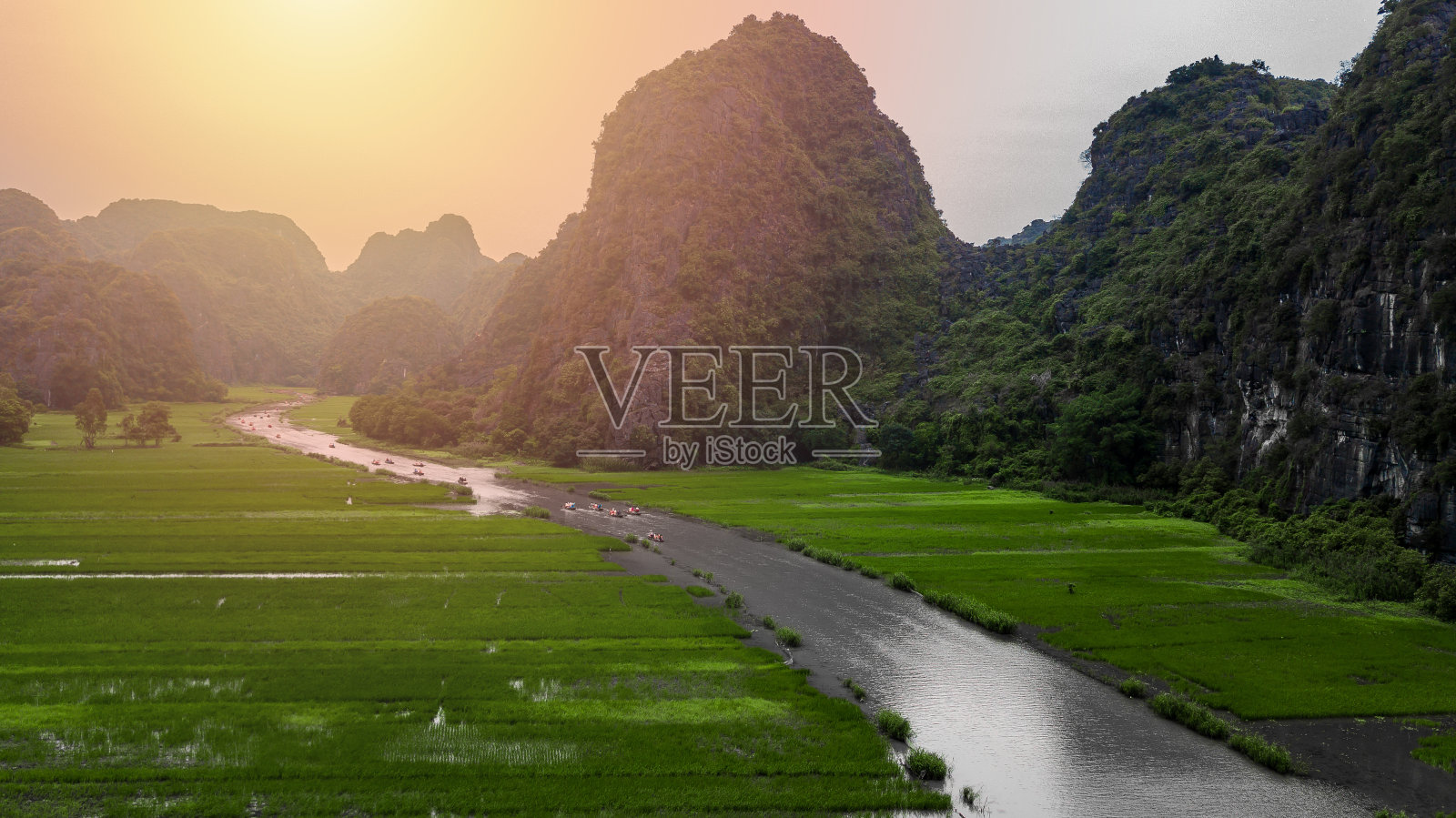鸟瞰图游客乘船沿Ngo洞河旅行和拍照的Tam Coc，桨手用脚推进桨，Tam Coc，宁平，越南。照片摄影图片
