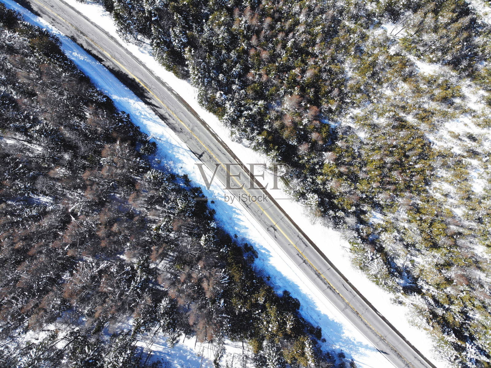 阿里尔看到一条孤零零的道路穿过一片积雪的森林照片摄影图片