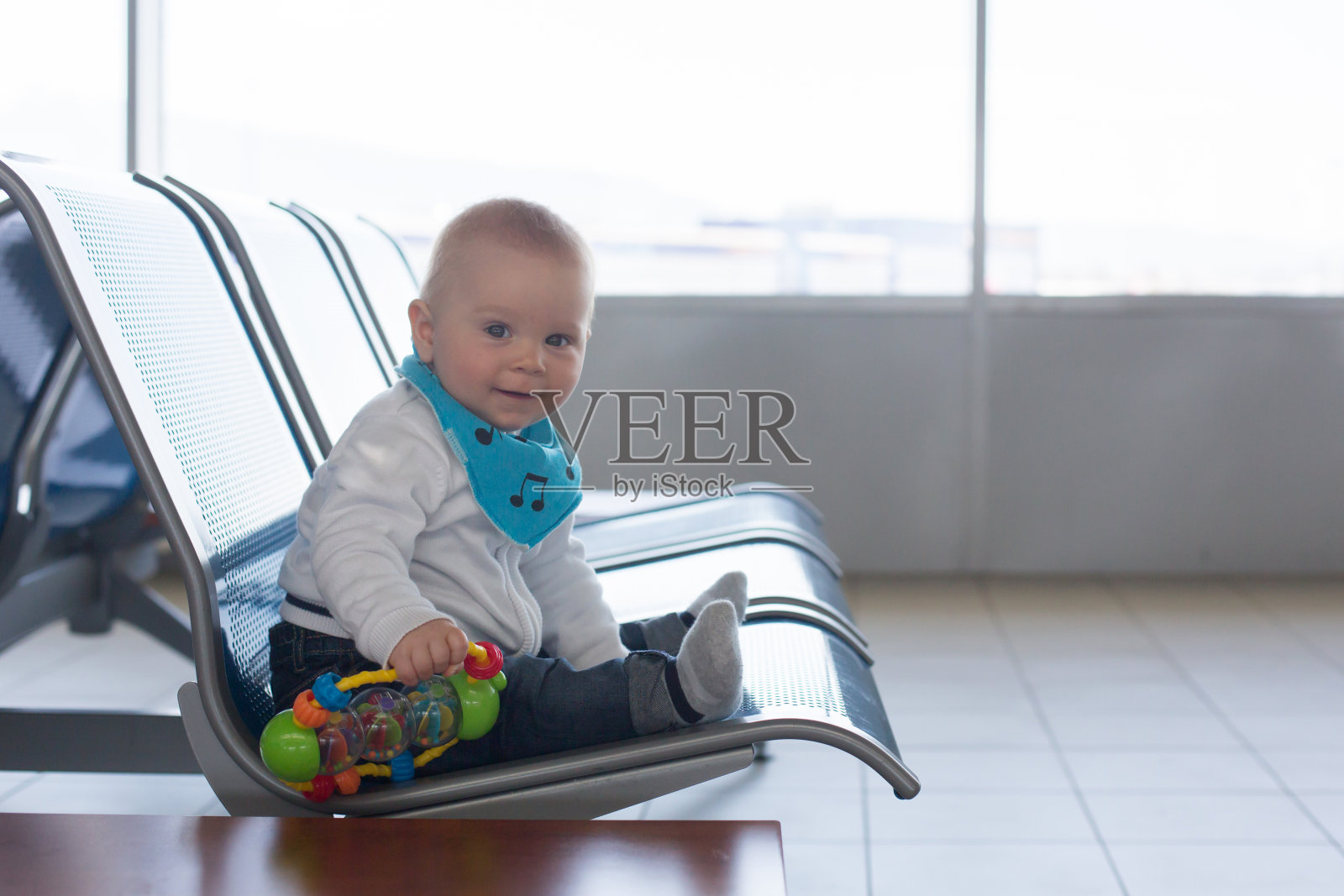 一个小孩，一个小男孩，在机场等待飞机起飞的时候玩耍照片摄影图片