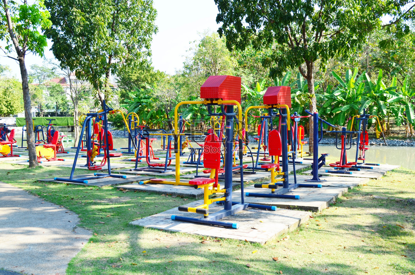 阳光下的公园里五颜六色的健身器材照片摄影图片