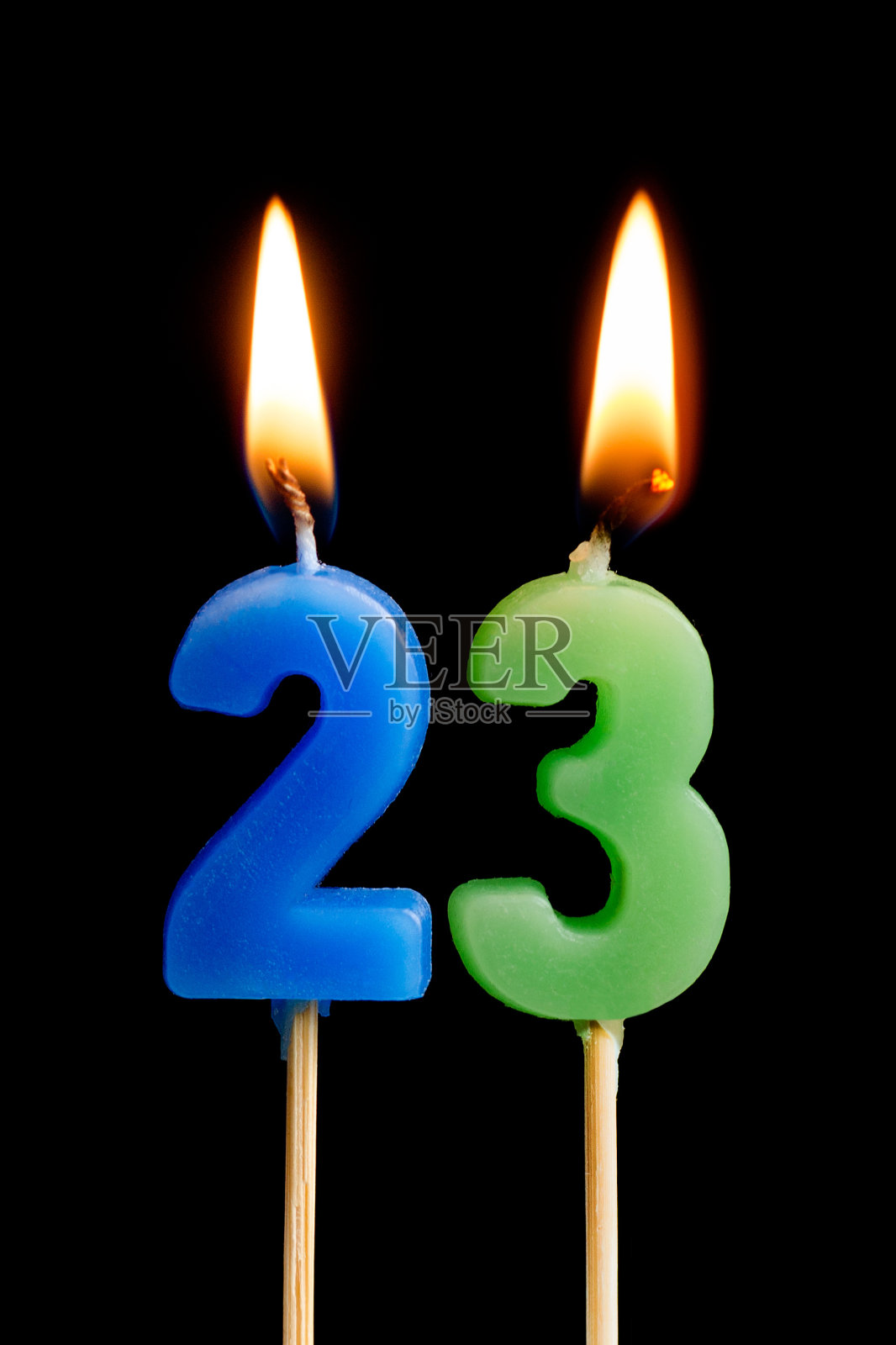 燃烧蜡烛23 23(数字，日期)的形式为蛋糕孤立在黑色的背景。庆祝生日、周年纪念、重要日期、节日、餐桌摆设的概念照片摄影图片