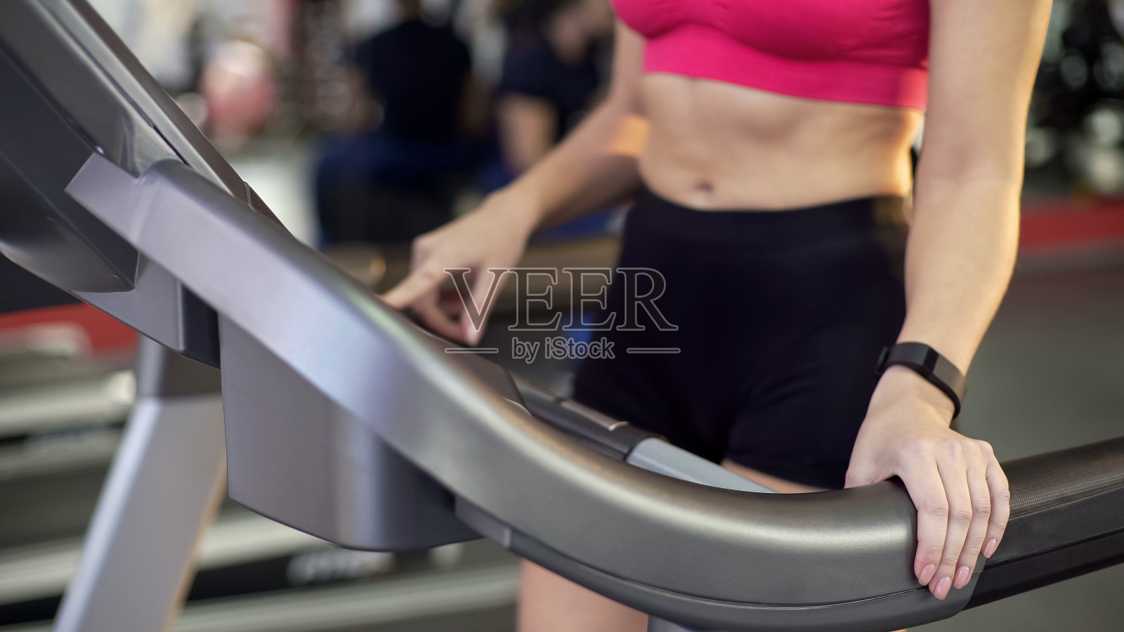 运动女士与平坦的腹部和苗条的身体在跑步机上锻炼，健身房健身照片摄影图片