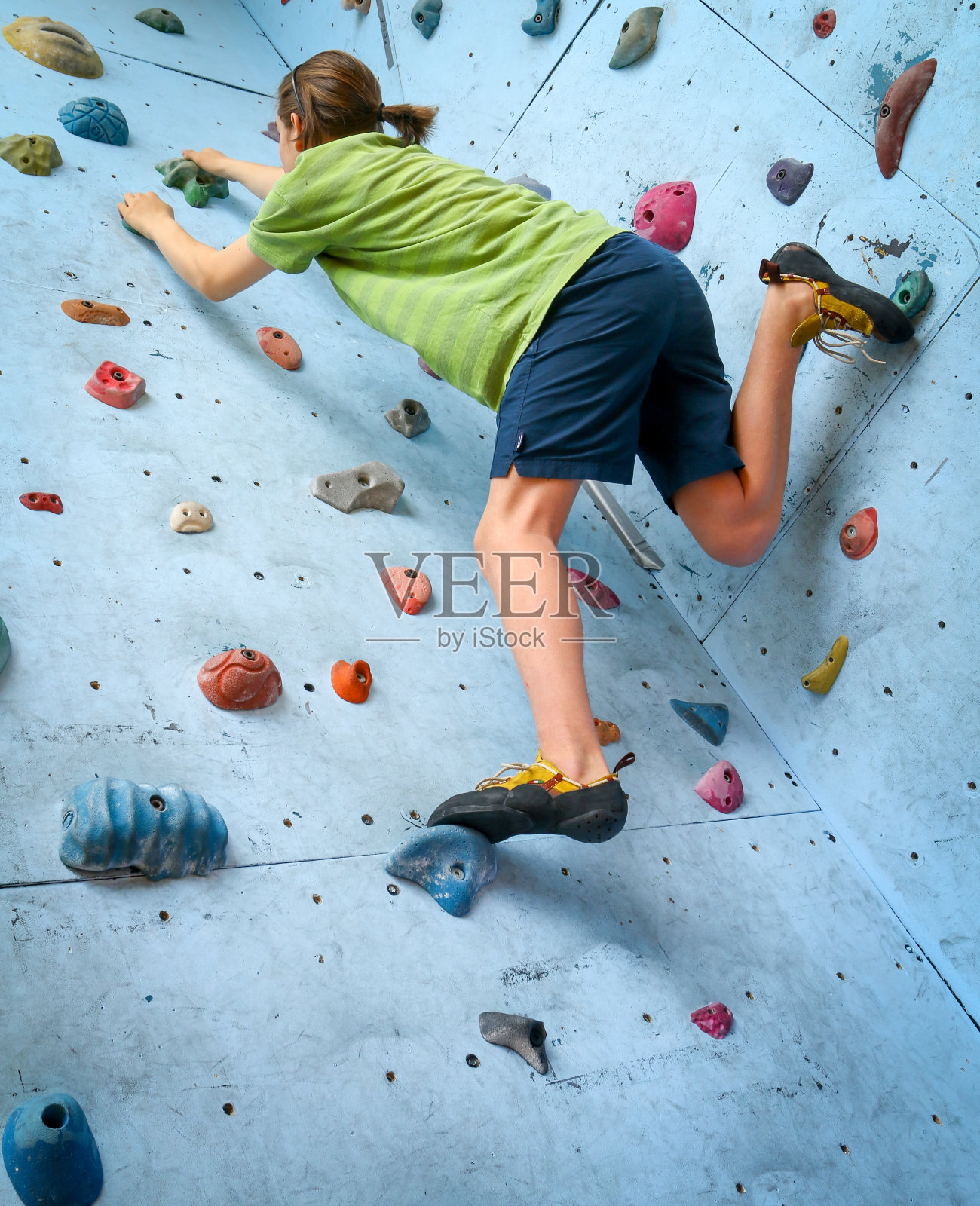 十几岁的男孩在室内攀岩墙上训练攀岩照片摄影图片