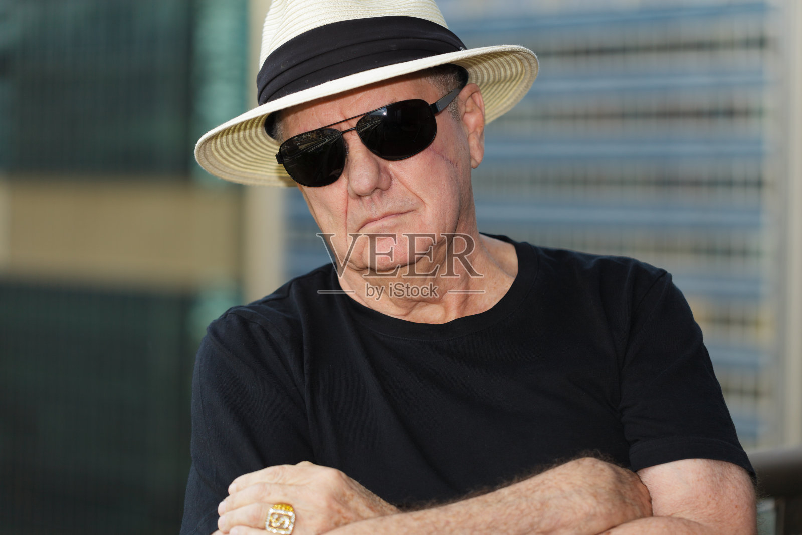 戴着帽子和太阳镜，脸上有疤的男人照片摄影图片