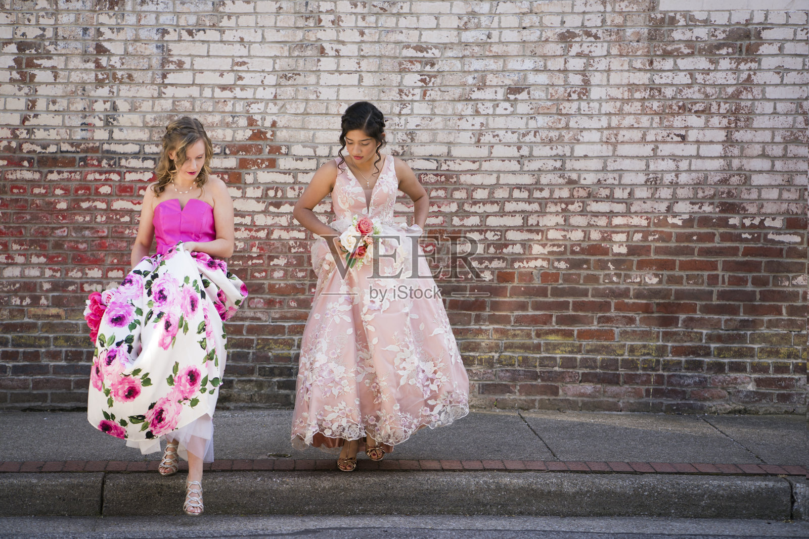两个十几岁的女孩穿着高跟鞋穿过街道照片摄影图片