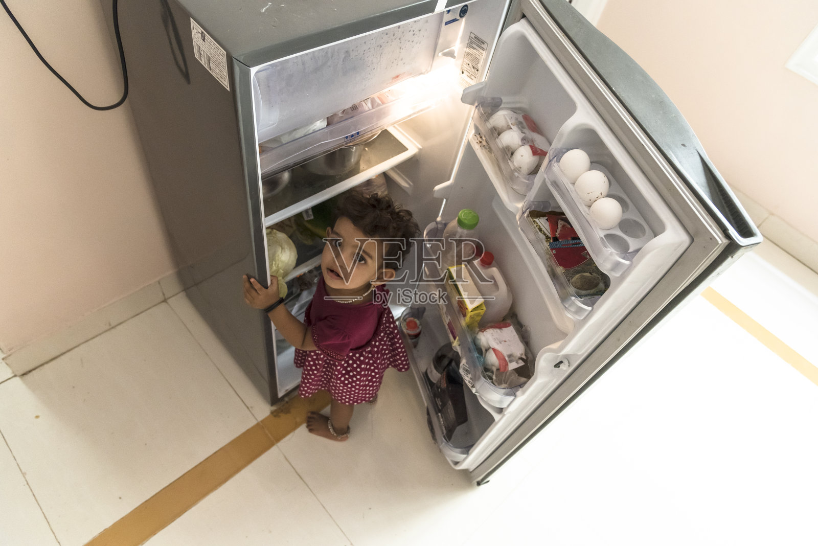 小女孩在冰箱里找东西吃照片摄影图片