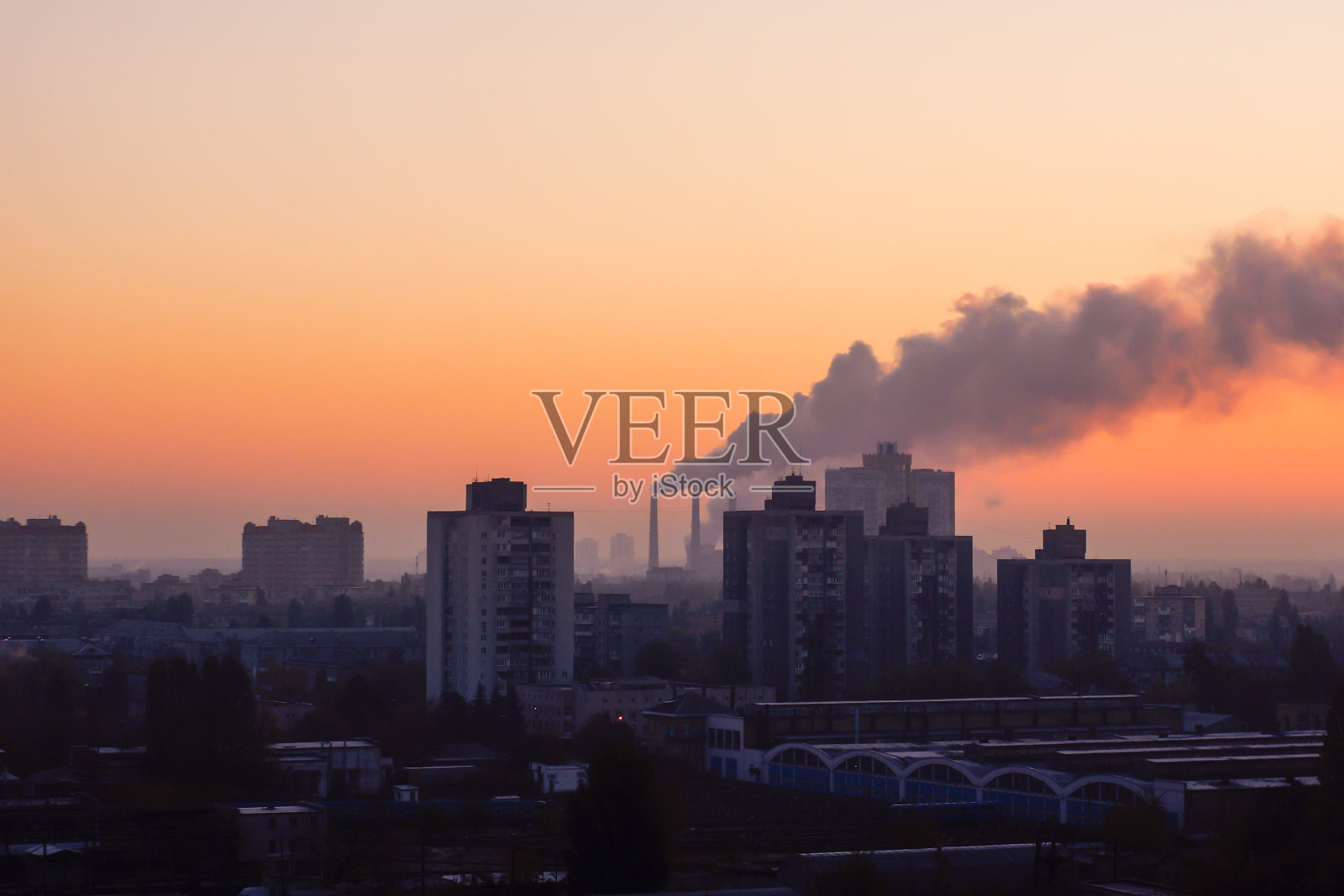 工厂的管道污染了夕阳下的空气，环境问题，烟囱里冒出的烟照片摄影图片