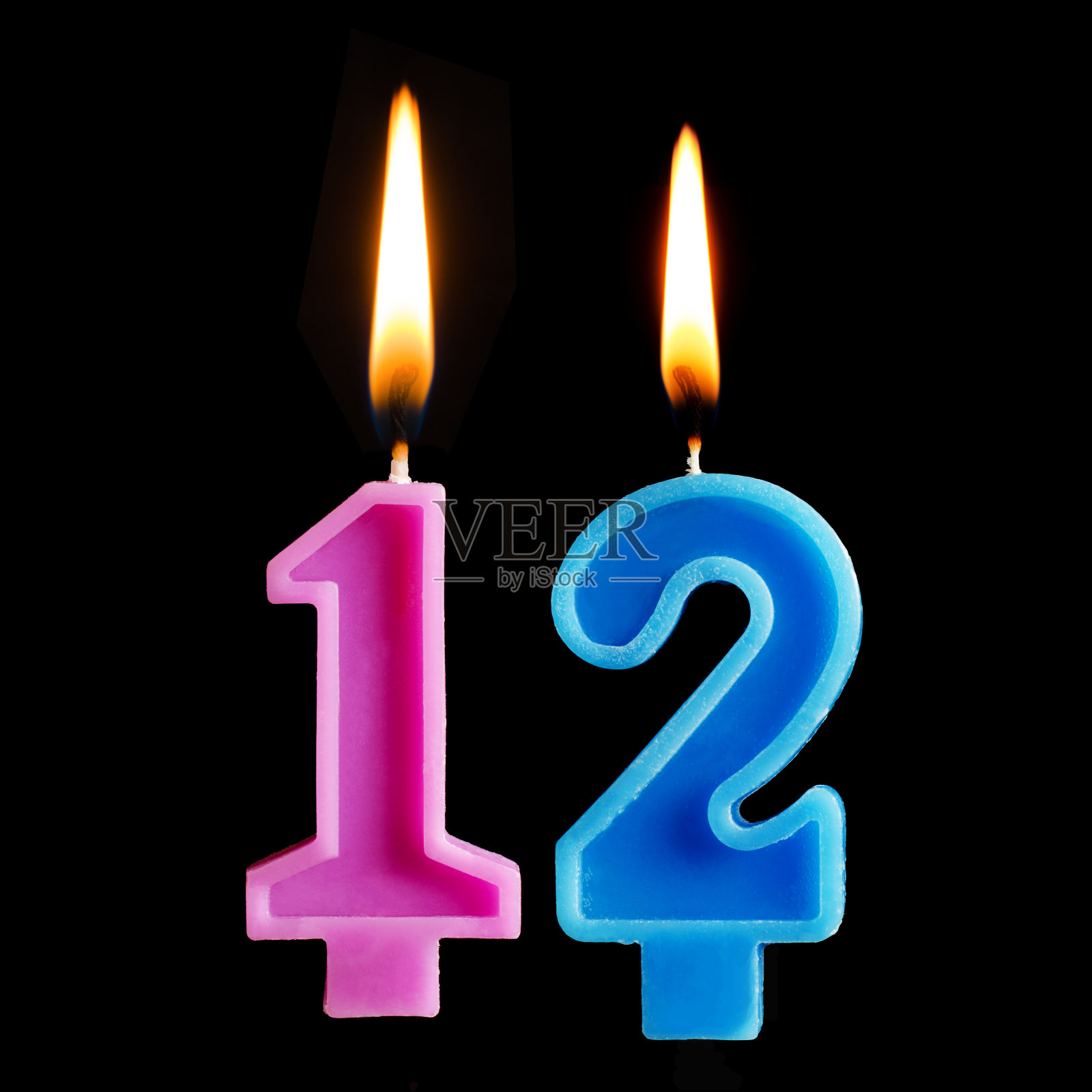 以12个数字的形式点燃生日蜡烛，蛋糕被孤立在黑色的背景上。照片摄影图片