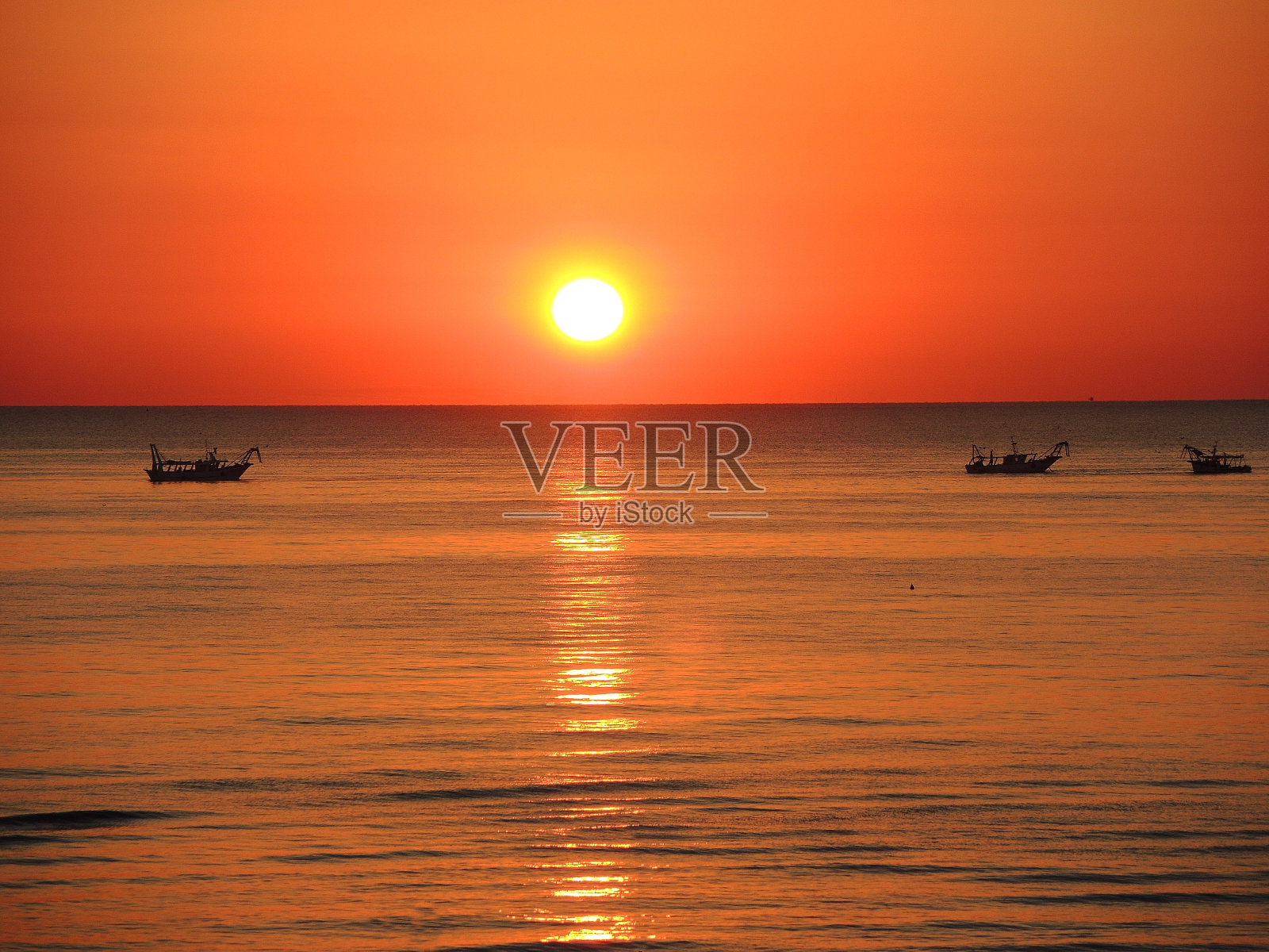 日出时渔船拉着网。亚得里亚海的成本。大区。意大利照片摄影图片
